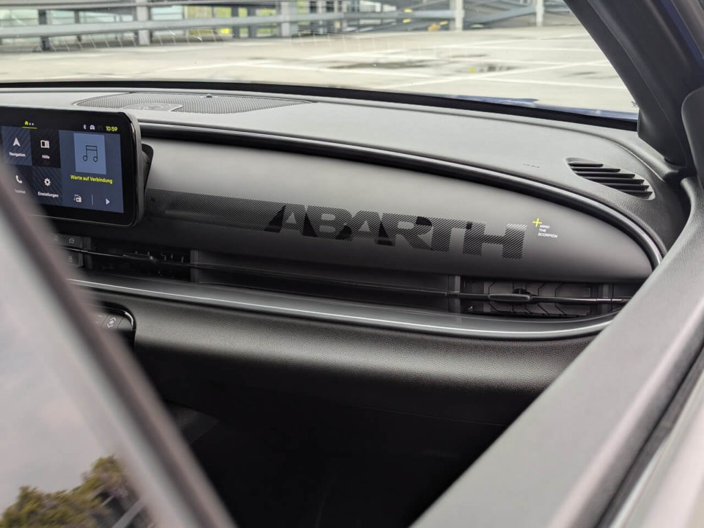 Abarth-Laser-Schriftzug (Interieur-Code 986) auf dem matt-schwarzen Armaturenbrett: "Mind the Scorpion"