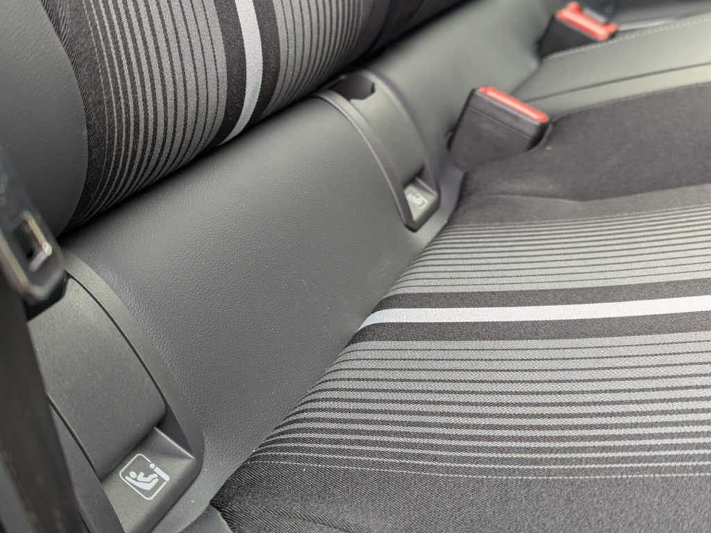 Isofix-Halterungen hinter Kunststoffklappen im Ford Capri. Zwei Kindersitze oder Babyschalen können auf den äußeren beiden Plätze der Rücksitzbank über Isofix und Top-Tether sicher befestigt werden.