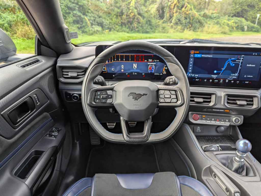 Sportlenkrad (Leder-Alcantara) mit blauen Ziernähten und digitaler Instrumentierung 12,4" im Ford Mustang Dark Horse 2025.