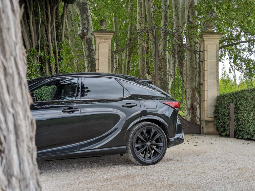 Elegantes Design: Geschwungene Heckpartie und mattschwarze Leichtmetallräder (21") beim LEXUS RX 500h F-Sport in der Lackierung Graphitschwarz 223