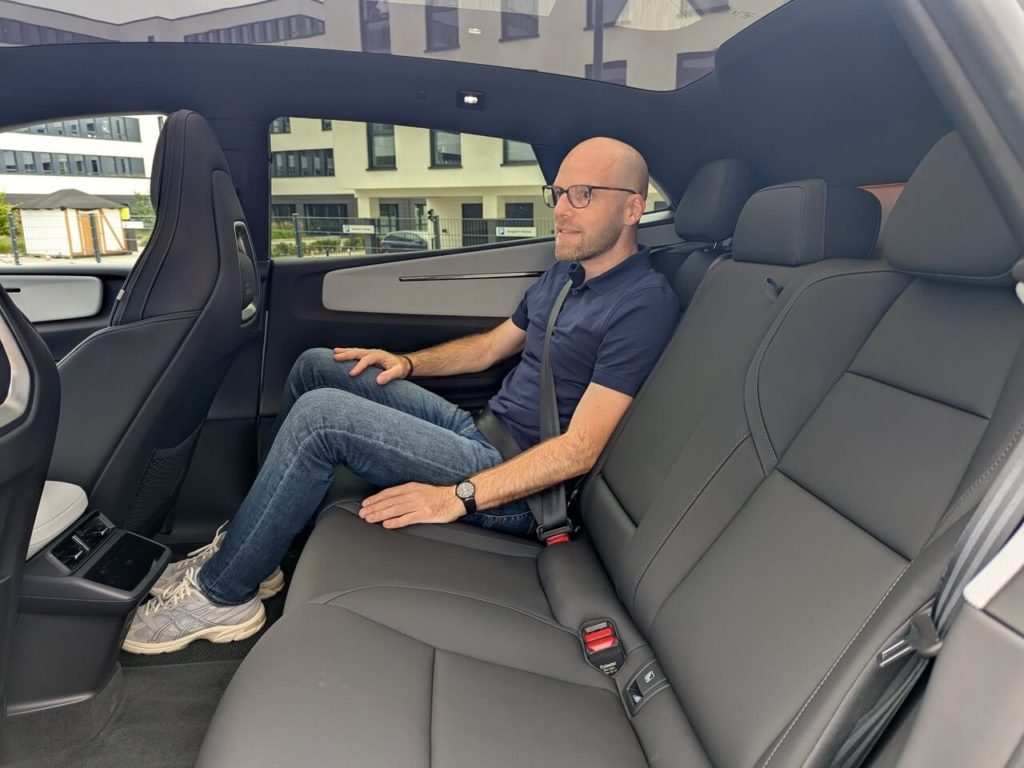 Rücksitzbank mit viel Beinfreiheit. Die Beine sind aufgrund der flachen Karosserie beim Polestar 4 leicht angewinkelt.