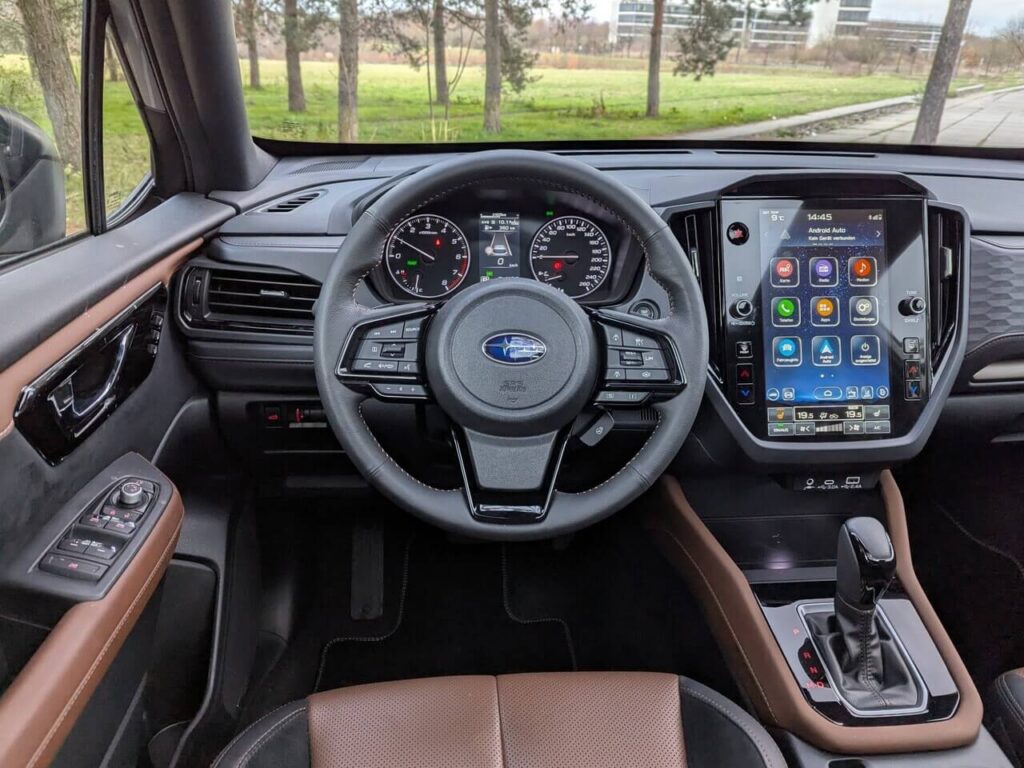 Fahrerperspektive (POV): Analoger Tacho mit Rundinstrumenten mit Digitalanzeige und 11,6 Zoll Touchscreen.