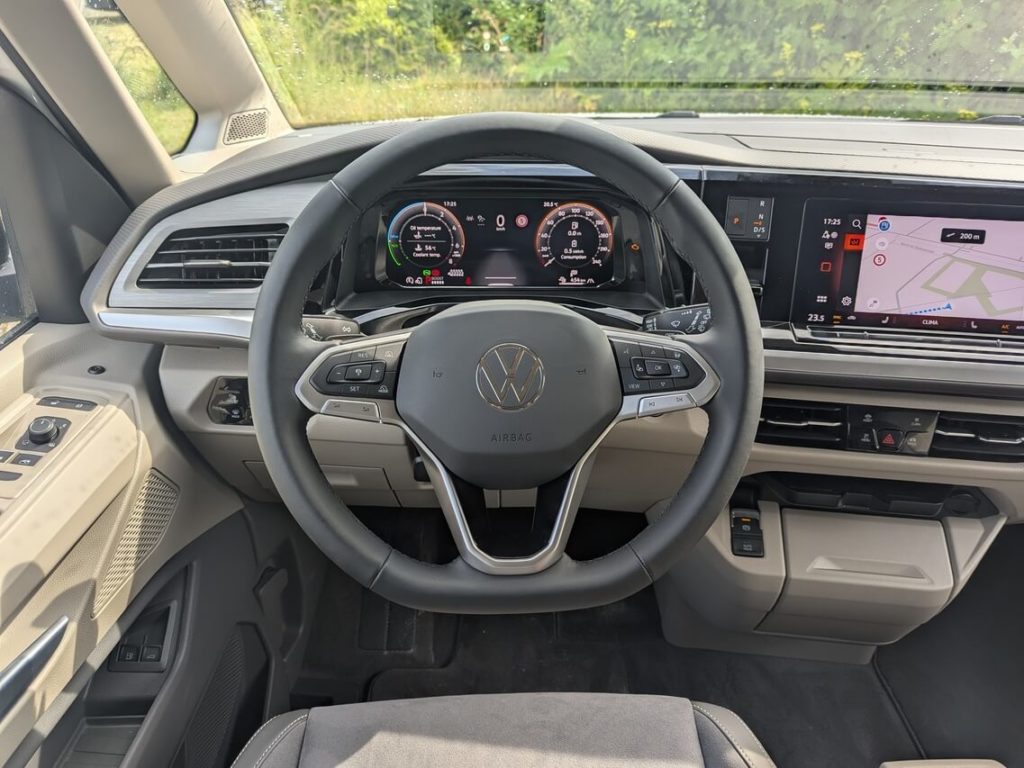 Fahrerperspektive im VW Multivan: Multifunktions-Lederlenkrad mit physischen Tasten und übersichtliches Cockpit mit 10,25 Zoll Digitaltacho.