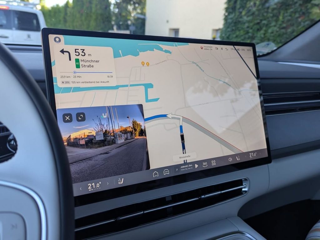 Navigationssystem (TomTom) auf dem 15,6 Zoll großen Zentraldisplay. Beim Abbiegen werden Kamerabilder eingeblendet.
