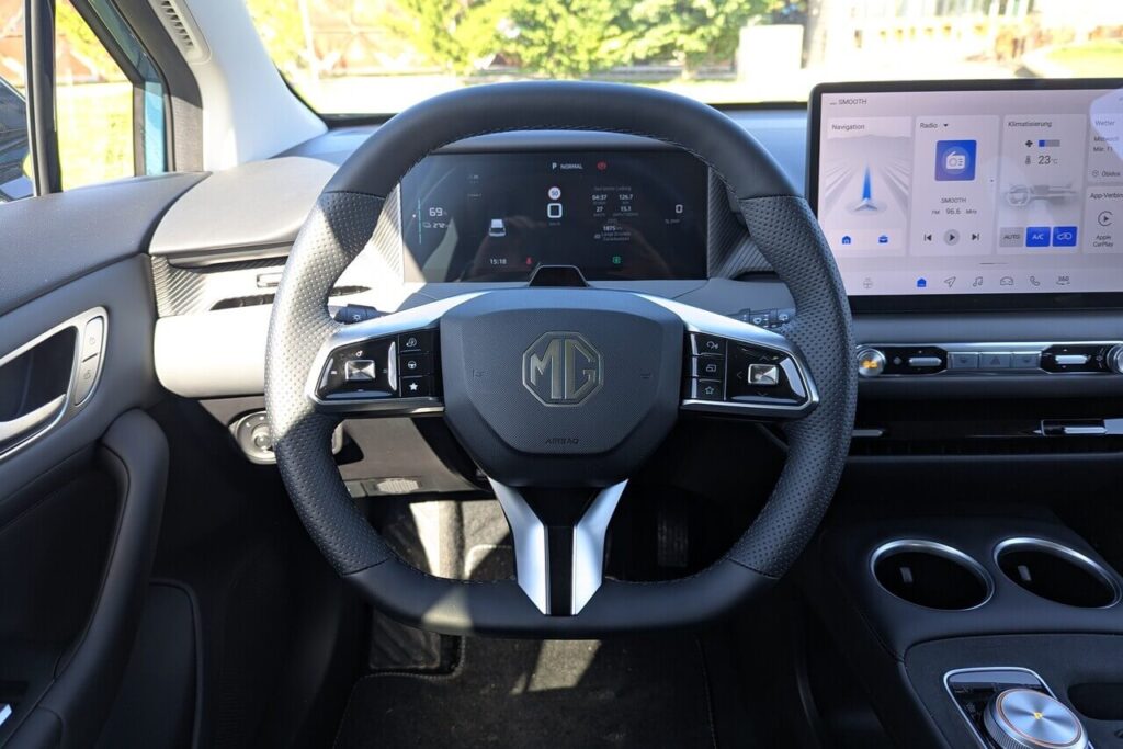 Fahrerperspektive (POV) beim neuen MG4 Facelift: Integriertes Fahrerdisplay in 10,25 Zoll. Sportlenkrad mit physischen Multifunktionstasten.
