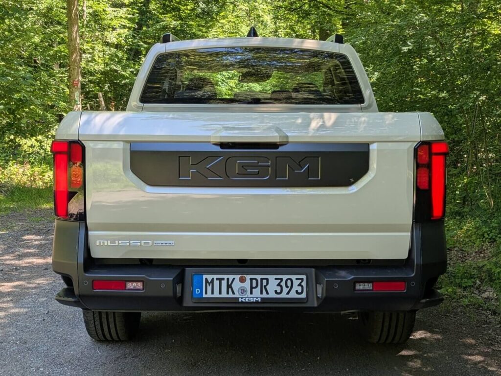 KGM Musso Pick-up Heckklappe mit schwarzem Inlay und großem Markenschriftzug. Seitlich befinden sich Trittstufen, die den Zugang zur Ladefläche erleichtern.