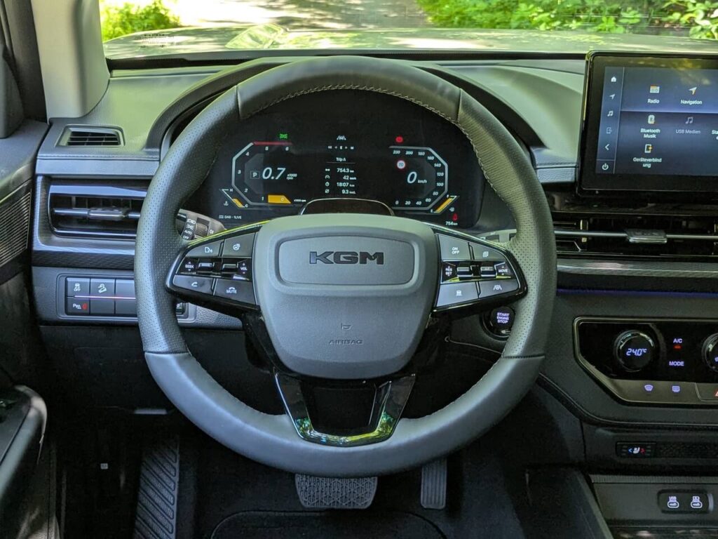 Lederlenkrad mit Multifunktionstasten und Digitaltacho in 12,3 Zoll (Fahrerperspektive).