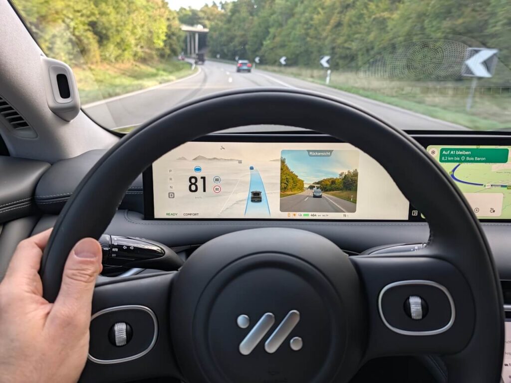 Fahrerperspektive im MG IM6: Übersichtliche Instrumentierung mit Anzeigen für Fahrerassistenzsysteme, undKamerabild vom Fahrzeug-Heck.