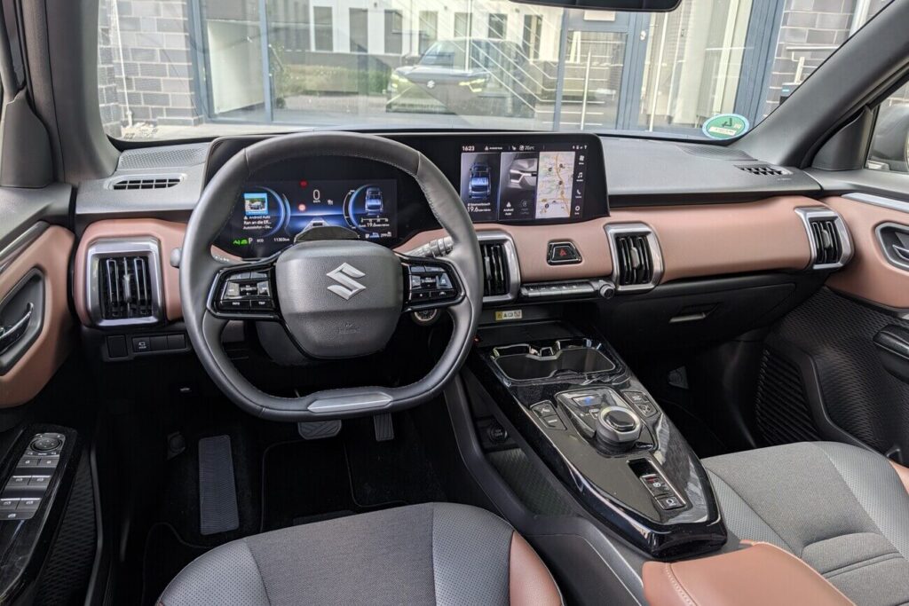 Armaturenbrett beim Suzuki e Vitara in Braun-Schwarz mit digitaler Instrumentierung (10,25") und Touchscreen (10,1")