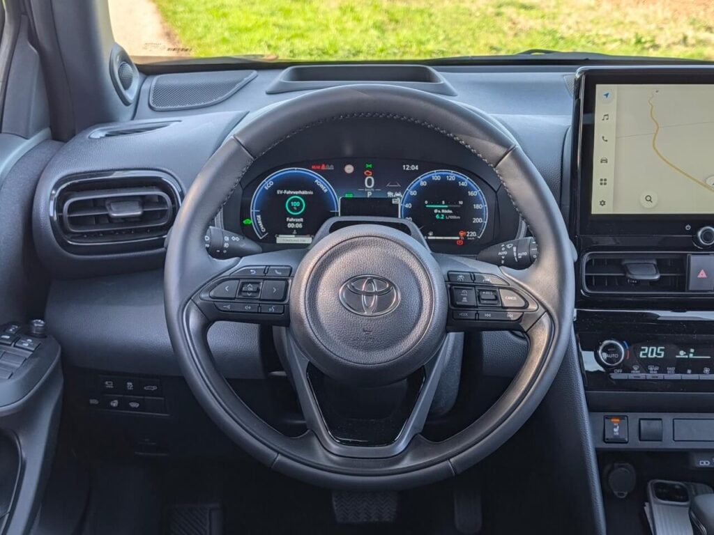 Fahrerperspektive im Toyota Yaris Cross (Facelift) mit digitaler Instrumentierung (12,3 Zoll) und Multifunktionslenkrad - hier Ausstattungsvariante "Lounge".