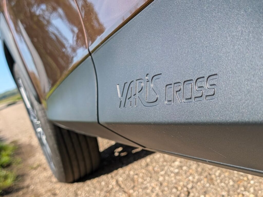 Seitenschweller mit "Yaris Cross" Schriftzug im Bereich der hinteren Tür.